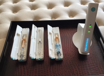 This image shows the Smartinjector™ holding three common syringe types and the user interface on the front of the device. (Image: QuiO)